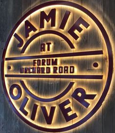 a sign that says james at the front of a building with lights around it and an oval