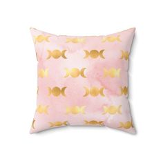 a pink pillow with gold foiled circles on the front and back, against a white background