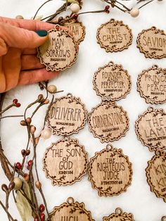 handmade wooden tags with the names of different towns on them and some berries around it