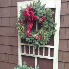 a christmas wreath is hung on an old window