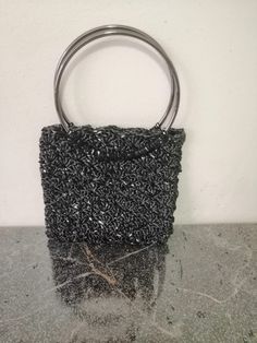 Hand-knitted handbag made of paper and velvet yarn, measuring 19 cm in width and 28 cm in length. This knitted bag is designed especially for women and makes a perfect gift for a loved one. With its stylish and elegant black color, it is an ideal choice for evenings or parties. Handmade Black Handheld Bag, Handmade Black Evening Bag For Gift, Handmade Black Handheld Evening Bag, Elegant Handmade Black Bag, Handmade Black Crochet Handheld Bag, Handmade Black Clutch Evening Bag, Elegant Hand Knitted Rectangular Shoulder Bag, Handmade Black Party Bag, Handmade Black Clutch Bag