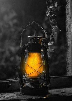 a yellow lantern sitting on top of a window sill