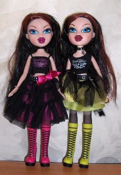 two dolls standing next to each other on a table