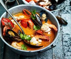 a bowl filled with seafood and mussels on top of a table