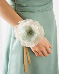 a woman wearing a green dress holding a flower in her hand