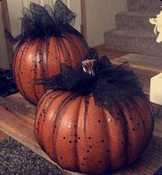 two pumpkins sitting on top of a wooden table