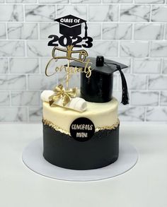 a graduation cake is decorated with gold and black decorations