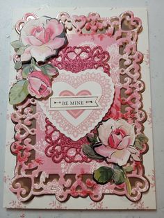 a card with pink roses and hearts on it, in the shape of a heart