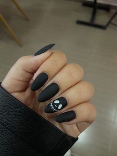 a woman's hand with black stiled nails