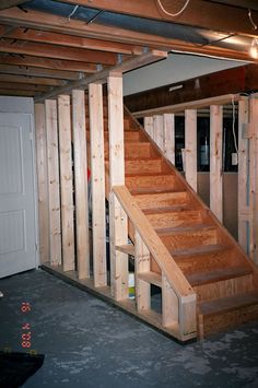 an unfinished basement with stairs and storage space