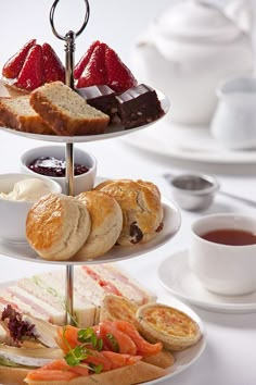 three tiered trays filled with different types of food and drinks on top of a table