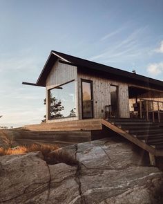 a wooden house sitting on top of a rocky hillside