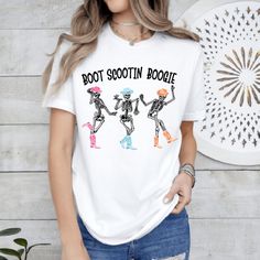 Boot Scootin Boogie T-Shirt, Halloween Skeleton t-shirt, Dancing Skeleton T-shirt, Spooky Tee, Cowboy Ghost shirt, Western Halloween Shirt 🌟Welcome to our collection of stylish and comfortable t-shirts specially designed for fashion enthusiasts!🌟 PRODUCT DETAILS: We take pride in using premium shirts from Bella Canvas and Gildan Soft Style for our prints. *Bella Canvas* - Unisex sizing - Lightweight at 4.2 oz. - Available in various compositions including 100% Combed Cotton, Ring-Spun Cotton, Fun Skull Print Crew Neck T-shirt, White Skull Print T-shirt For Fall, White T-shirt With Skull Print For Fall, Fun Short Sleeve T-shirt With Skull Print, Casual Skull Custom Print T-shirt, Boot Scootin Boogie, Cowboy Ghost, Western Halloween, Skeleton T Shirt