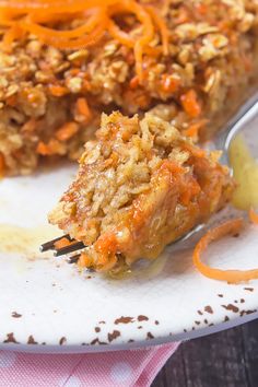 a fork with some food on it sitting on a plate next to another piece of cake