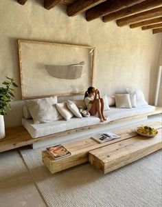 a woman sitting on a white couch in a living room next to a coffee table