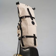 a large canvas bag sitting on top of a black and gold motorcycle handlebars