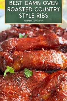 the best damn oven roasted country style ribs are on a white plate with green leaves