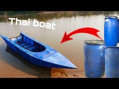 a blue boat sitting on top of a body of water next to two large cans