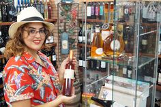 a woman in a hat holding a bottle of wine