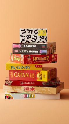 a stack of books sitting on top of each other in front of a pink wall