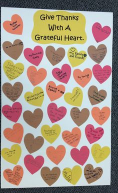 a bulletin board with lots of hearts and words written on the front, in different colors