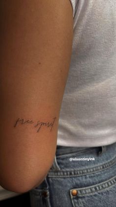 a woman's arm with the word free spirit written in cursive font