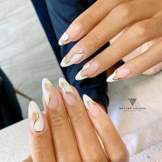 15 White and Gold Nails Perfect for Any Occasion Beautiful Dawn Designs White And Gold Nail Designs Almond, White And Gold Nail Ideas Simple, White Nails With Gold Accent French Tips, White Abstract Nails Almond, Cute White And Gold Acrylic Nails, White And Gold Acrylic Nails Almond, Almond French Tip Nails With Gold Design, Cream And Gold Nail Designs, White And Gold Nails Simple Almond