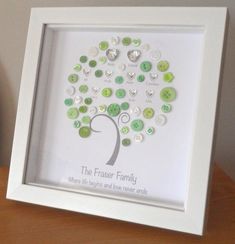 a family tree with green and white buttons in the shape of a heart is displayed on a table