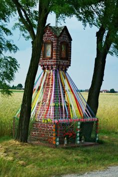 a small tower made out of plastic wrapped around trees in the middle of a field