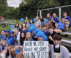 a group of young people sitting next to each other on a bleachers bench