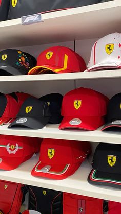 many ferrari hats are on display in a store, one is red and the other is black