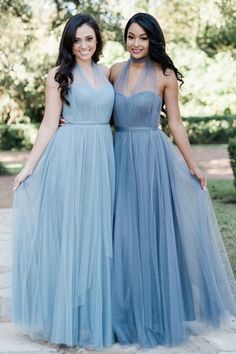 two women in blue dresses standing next to each other