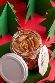 a jar filled with peanut butter sitting on top of a green and red table cloth