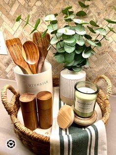 wooden utensils are arranged in a basket next to a potted plant