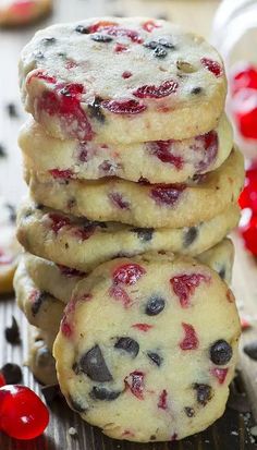 several cookies stacked on top of each other with cherries in the background and text overlay that reads, cherry chocolate chip cookies