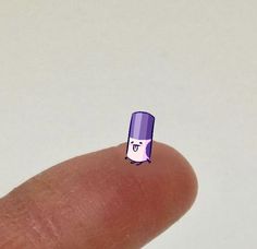 a finger with a sticker on it that has a purple hat on top of it