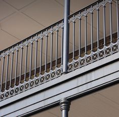 a close up of a street sign on a pole near a building with balconies