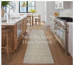 a kitchen with wooden floors and white walls, along with the words new neutrals have arrived