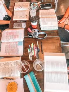 several people sitting at a table with books and pens