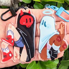 three cartoon keychains in the palm of someone's hand