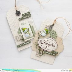 two tags are hanging from twine on a white table with green trimmings