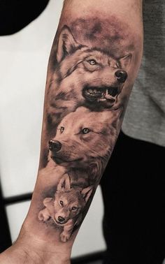 a man's arm with two wolfs on it and one is holding the other