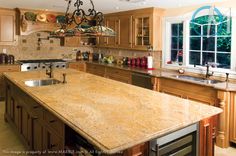 a large kitchen with marble counter tops and wooden cabinets