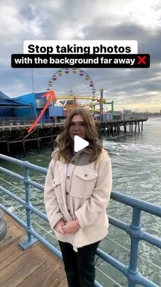 a woman standing on a pier next to the ocean