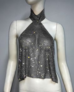 a mannequin wearing a black and white top with gold sequins on it