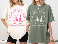 two women standing next to each other wearing t - shirts with wine glasses on them