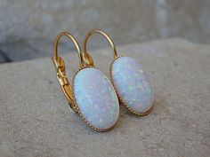 Bridal White Fire Opal Earrings for Bride Earrings, Oval Opal Earrings, October Birthstone Earrings, Leverback Gold Earrings, Opal Jewelry These stunning oval white opal leverback earrings have a great statement look that can't be missed. They would be great for women, bridesmaid or bride. Metal: 24K Gold Plate Gemstone: Opal lab Stone Size: 10mm X 14mm FOR MATCHING RING: https://www.etsy.com/il-en/listing/252232392/opal-gold-ring-gemstone-ring-white-opal?ref=shop_home_active_7 FOR ROUNDED WHITE Oval Wedding Earrings With Lever Back Ear Wires, Clip-on Oval Cabochon Earrings For Gifts, White Oval Earrings With Ear Wire, White Lever Back Earrings As Gift, White Lever Back Earrings For Gift, Oval Clip-on Earrings For Gift, White Oval Earrings, Opal Earrings Vintage, Earrings For Bride