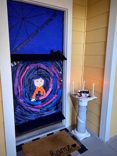 a decorated front door with a welcome mat and lit candles