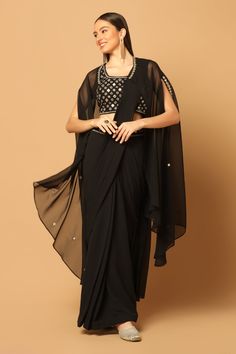 Black cape with scattered mirror and thread embroidery. Comes with waistband embroidered pre-draped saree and an unstitched blouse fabric.
Components: 3
Pattern: Embroidery
Type Of Work: Mirror and Thread
Fabric: Georgette
Color: Black
Other Details: 
Saree with embroidery on the waistband
Open front cape with asymmetrical hem
Note: Clutch held and stitched blouse worn by the model are not for sale
Occasion: Sangeet - Aza Fashions Embroidery Mirror, Draped Saree, Black Cape, Drape Saree, Black Saree, Pattern Embroidery, Two Sisters, Thread Embroidery, Fashion App