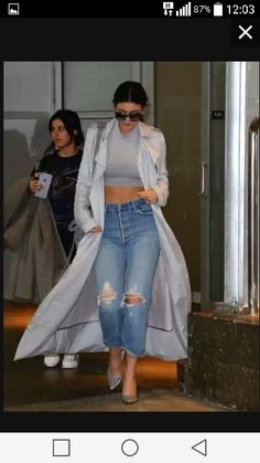 a woman in ripped jeans and grey coat